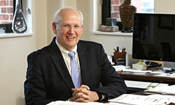 Dr. Raymond DuBois sits at his desk in his office